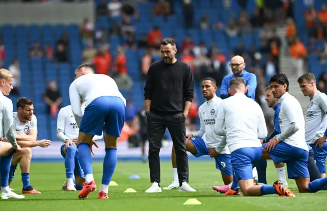 De Zerbi stands in the middle of Brighton's players as they warm up.