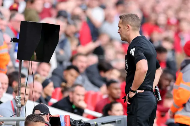 Referee, Craig Pawson checks the Video Assistant Referee during the Premier League match