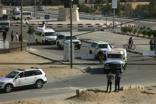 UN and Red crescent cars drive on a road by a border crossing