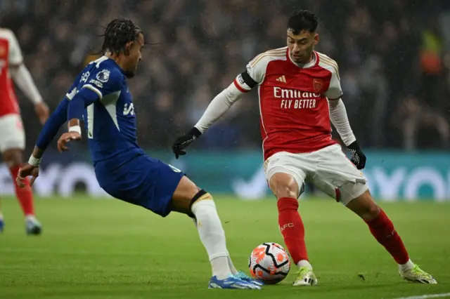 Martinelli tries to dribble past Malo Gusto.