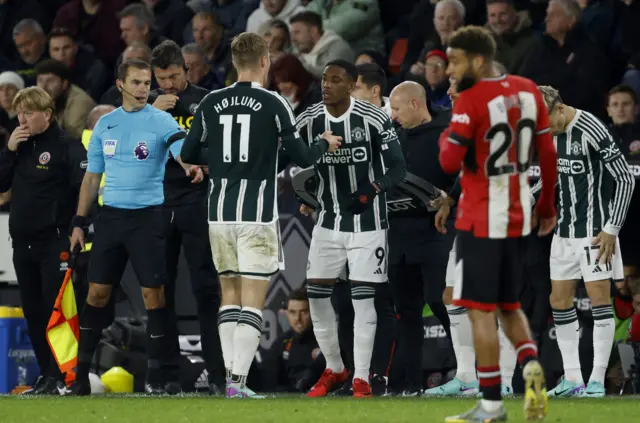 Hojlund low fives his replacement Martial as they pass by one another on the touchline.