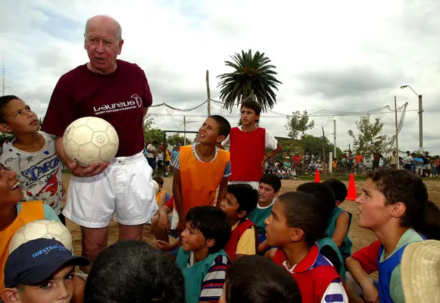 Bobby Charlton speaks to children from the Gonzalo Rodriguez Memorial Foundation project during the final day of the Laureus Sport For Good Foundation South American tour on February 28, 2003 in Montevideo, Uruguay