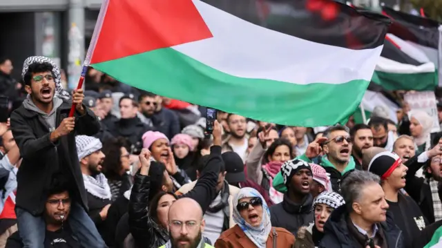 A crowd of protesters holding flags and signs in support of Palestine in Duesseldorf