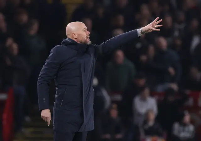 Ten Hag gestures to his players from the sideline.