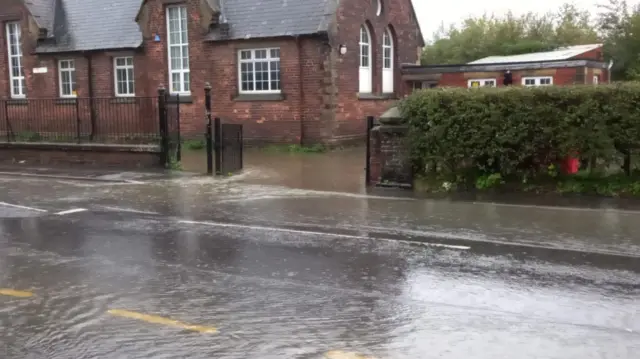 Flooded road outside school in Penyffordd, Flintshire