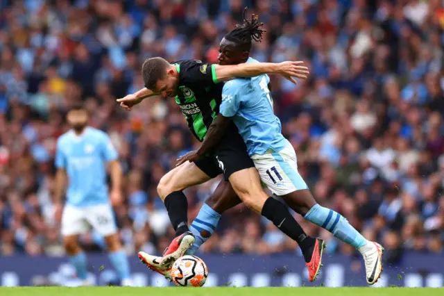 James Milner of Brighton & Hove Albion is challenged by Jeremy Doku