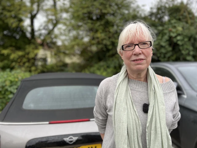 Claire Goddard in front of her car