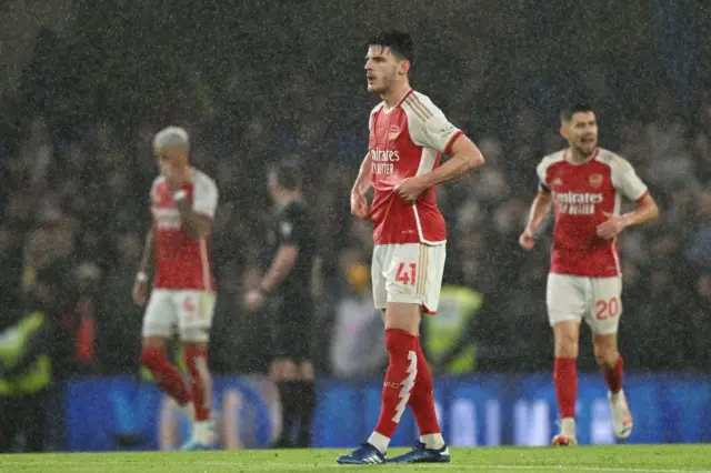 Arsenal players stand stunned after Chelsea's opening goal.