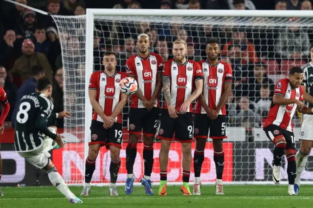 Fernandes takes aim over the Sheffield United wall.