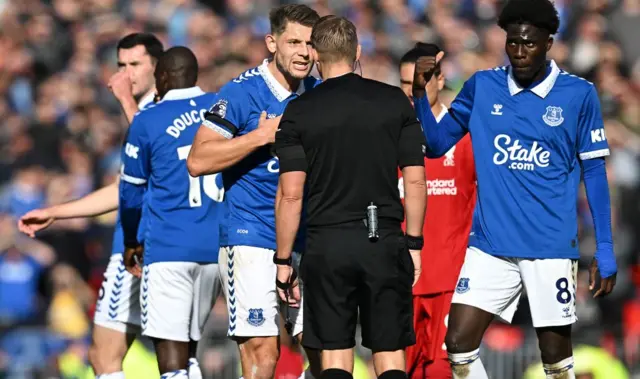 James Tarkowski and Amadou Onana  remostrate with Referee