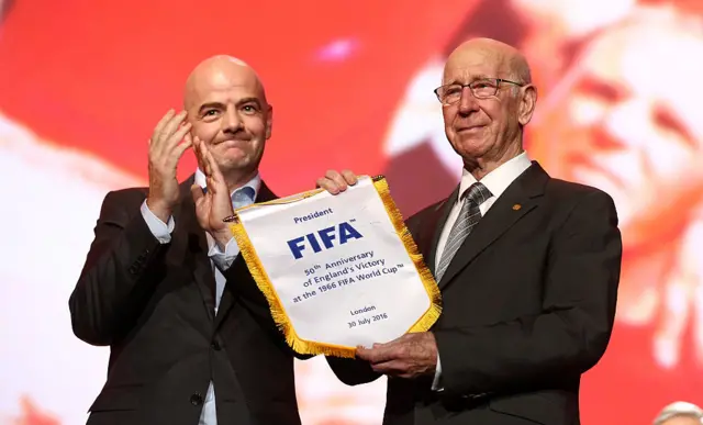 Sir Bobby Charlton receives a pennant from Fifa to commemorate the 50th anniversary of England's World Cup win