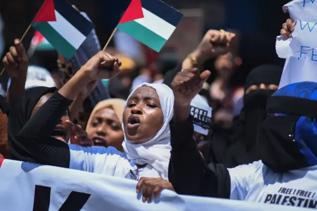 Protesters hold flags and signs in support of Palestine in Mombasa