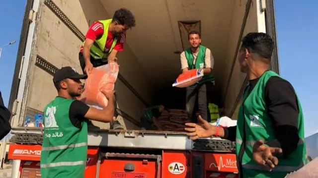 People unload aid on the Egyptian side of the Rafah crossing