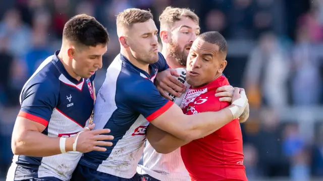 Tonga player tackled by England