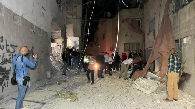 People inspect the damage after an Israeli strike hit a compound beneath a mosque that the Israeli military said was being used by militants to organize attacks, in Jenin refugee camp in the Israeli-occupied West Bank, October 22, 2023.