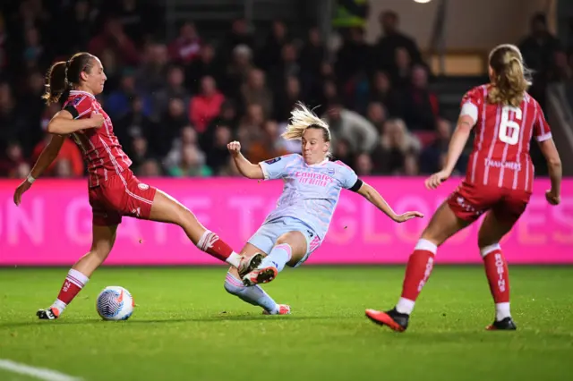 Beth Mead of Arsenal shoots whilst under pressure from Naomi Layzell