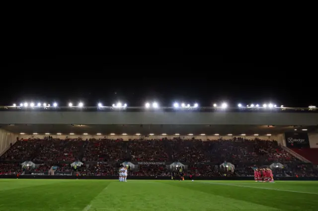 Players, fans and match officials observe a minutes silence in remembrance of the victims of the recent attacks in Israel and Gaza