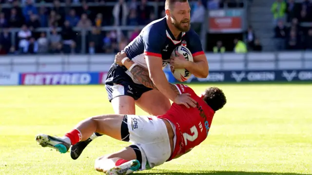 Elliott Whitehead tackled by Tonga