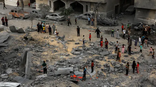 Palestinians gather at the site of Israeli strikes on a house in Khan Younis