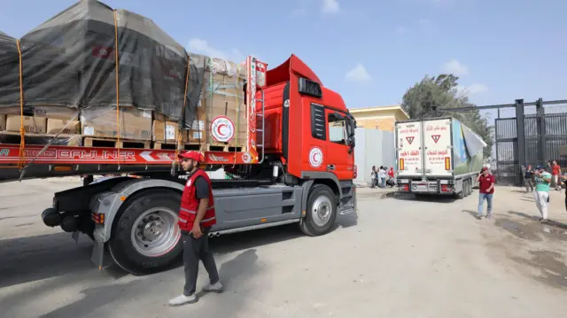 Trucks carrying humanitarian aid for the Gaza Strip cross the Rafah border gate, in Rafah, Egypt, 22 October 2023.