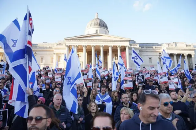 People gathered in Trafalgar Square for a rally in solidarity with Israel hold up the Israeli flag