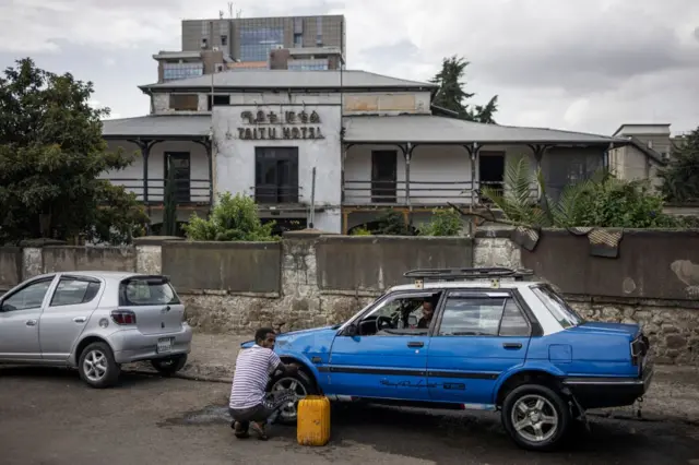 A man washes a taxi in the historical Piazza neighbourhood of Addis Ababa on October 21, 2023. (Photo by Michele Spatari