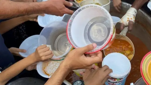 People offer up plastic containers to be filed with food