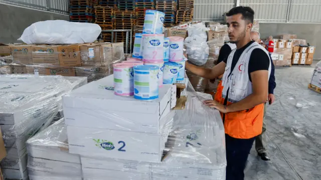 A Red Crescent worker sorts aid before being distributed to Palestinians, as the conflict between Israel and Palestinian Islamist group Hamas continues, in Khan Younis in the southern Gaza Strip, October 23, 2023.