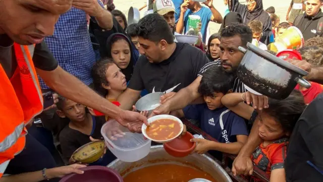 Children queue with adults for food from the UN volunteers