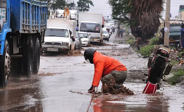 A motor cyclist tries to get up after falling into a flooded ditch following heavy rainfall October 29, 2015, in the capital Nairobi. According to the weather forecast, the El Nino weather phenomenon is expected to hit Kenya, but says it is unlikely to unleash the fury and destruction of 1997