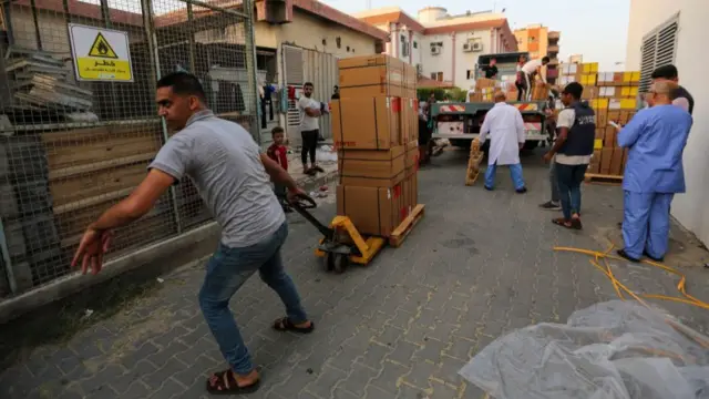 People distribute aid in Khan Younis after a convoy of trucks carrying essential supplies arrived through the Rafah crossing