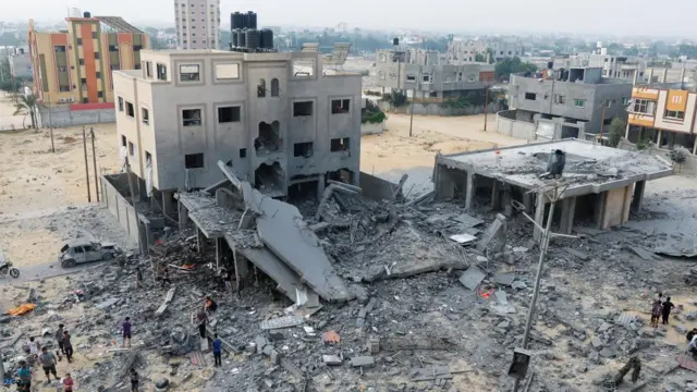 A blasted and part-collapsed building in Khan Younis, surrounded by rubble