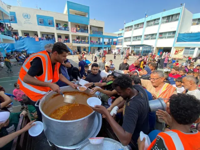 Food being distributed in Rafah on Monday, at one of the many UN-run schools in Gaza that are serving as shelters and food centres