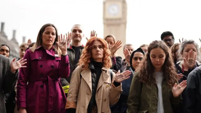 People attend a vigil to mourn the children killed in Gaza with attendees displaying the names of dead children on their palms at the event organized by non-profit organization 'Medical Aid for Palestinians' at Parliament Square in London, Britain, 24 October 2023