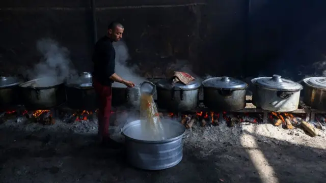 A man cooking food over coals