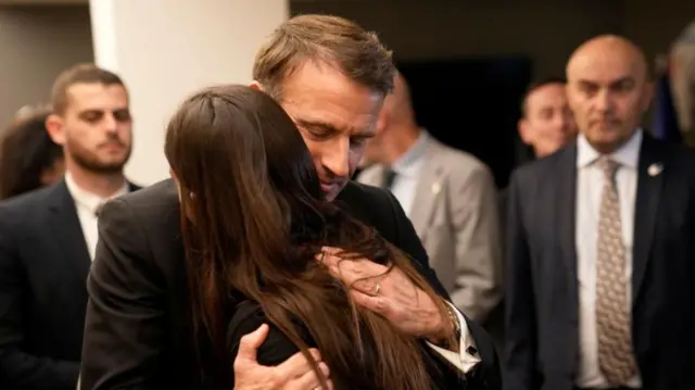 French President Emmanuel Macron hugs a woman as he meets Israeli-French nationals Ben Gurion airport