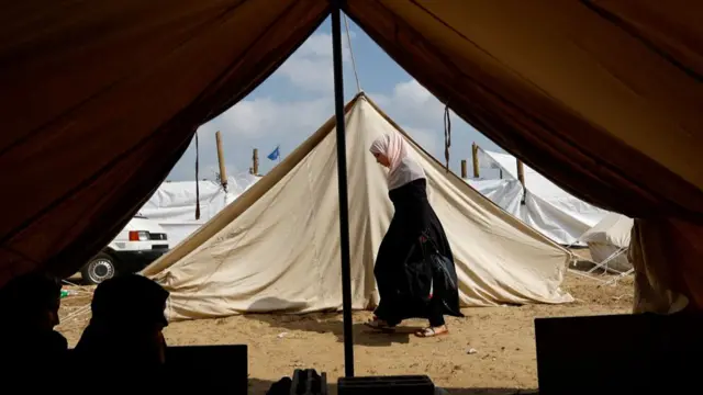 Woman walking past tents