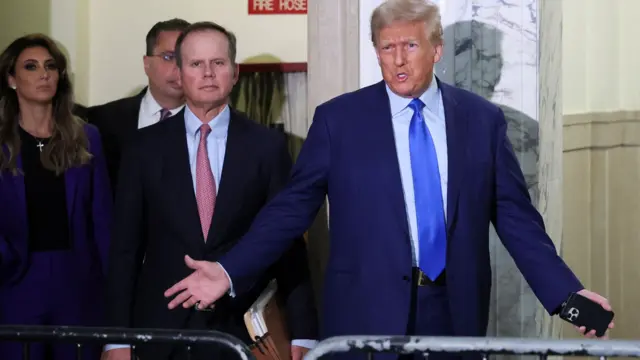 Donald Trump in a suit gesturing and walking