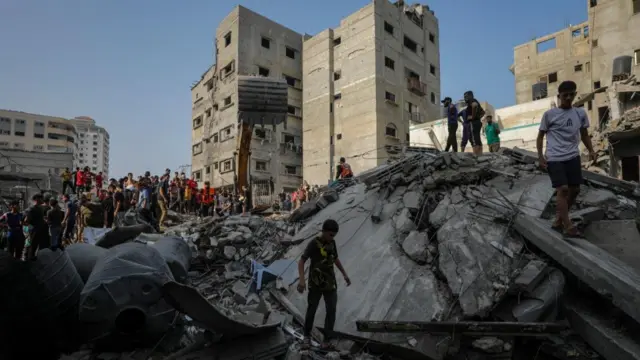 People walk on the rubble of a destroyed building in Gaza