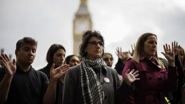 People attend a vigil to mourn the children killed in Gaza with attendees displaying the names of dead children on their palms at the event organized by non-profit organization 'Medical Aid for Palestinians' at Parliament Square in London, Britain, 24 October 2023.