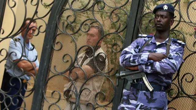 A Sudanese policeman (R) stands guard outside the French embassy in Khartoum on July 15, 2008