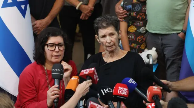 Yocheved Lifschitz (C), 85, speaks with the media next to her daughter Sharone Lifschitz