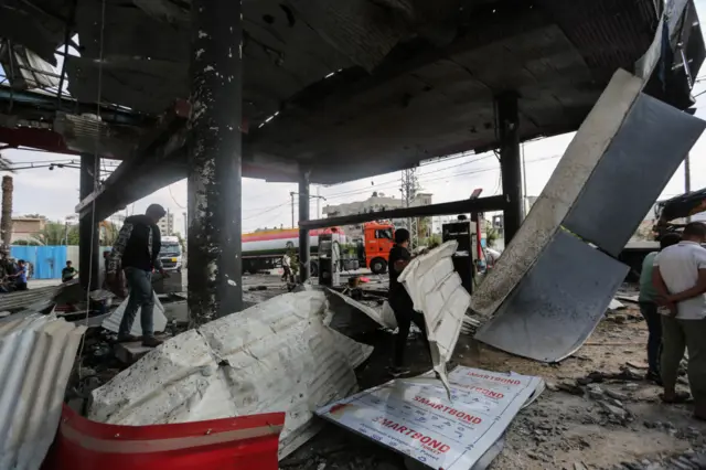 Inside a petrol station which was hit by strikes, with people now picking through rubble