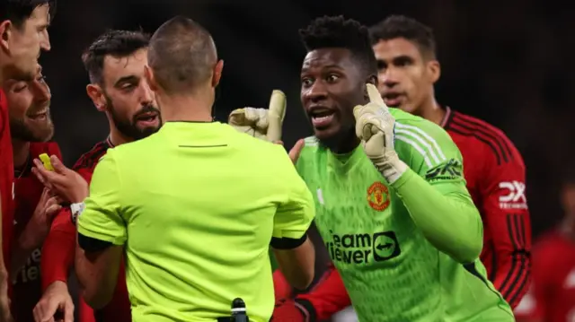 Andre Onana argues with the referee