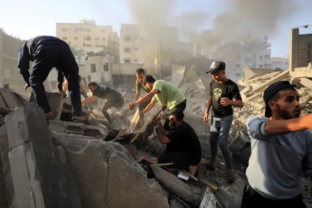 Palestinians search for casualties at the site of an Israeli strike