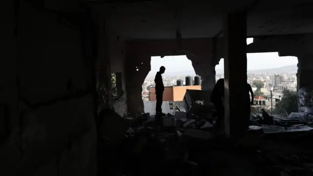 A man inspects rubble following the strike in Jenin