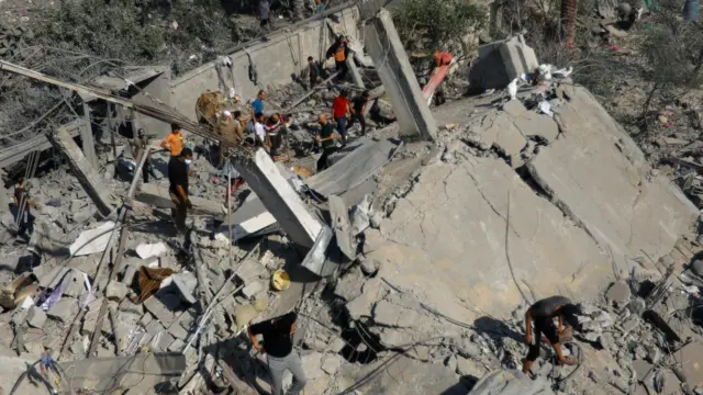 Palestinians search for casualties following an Israeli strike on a house, in Khan Younis, in the southern Gaza Strip, October 25, 2023.