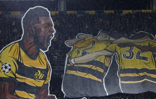 Banner of players in stands held by Young Boys fans