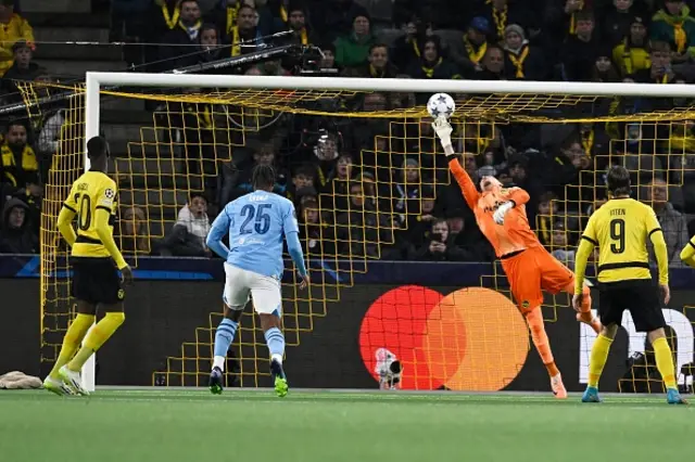 The ball hits the bar as the goalkeeper dives for it