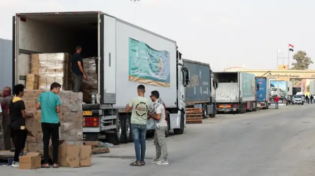 Lorries carrying aid queue on the Egyptian side of the Rafah border crossing